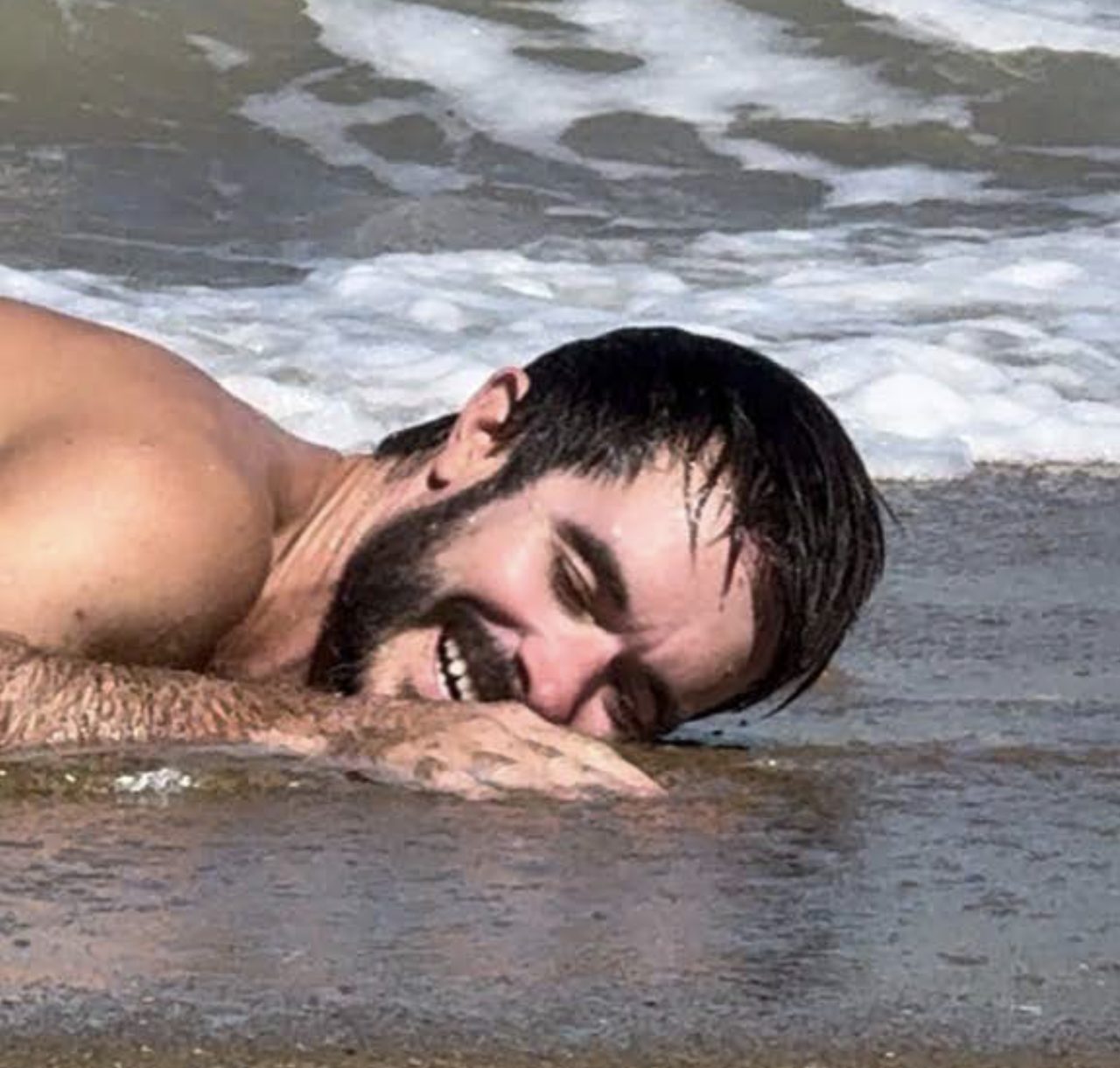 A skimboarder mid-wipeout in shallow water, board flying.