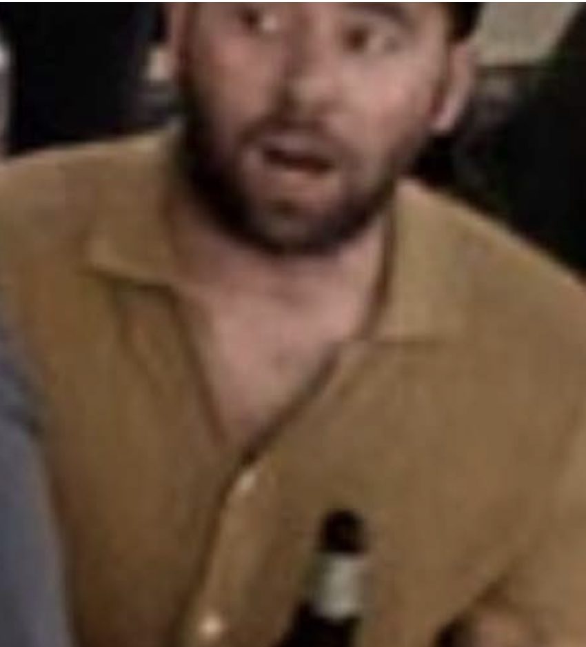 A man doubled over laughing in the living room.