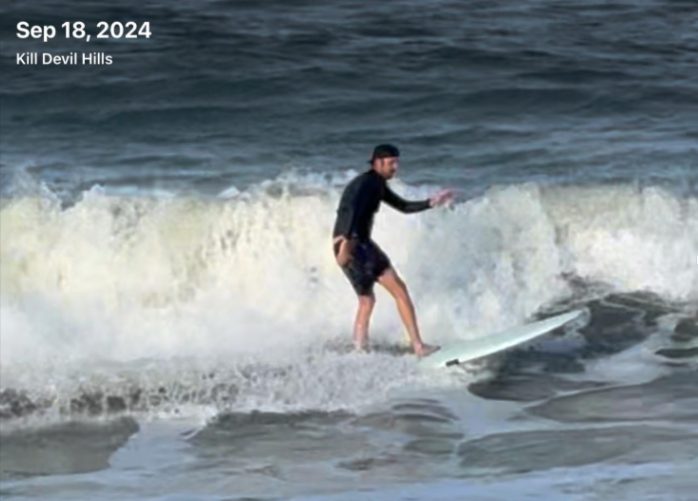 A video still dated September 18, 2024 of a surfer riding heavy shore break at Kill Devil Hills.