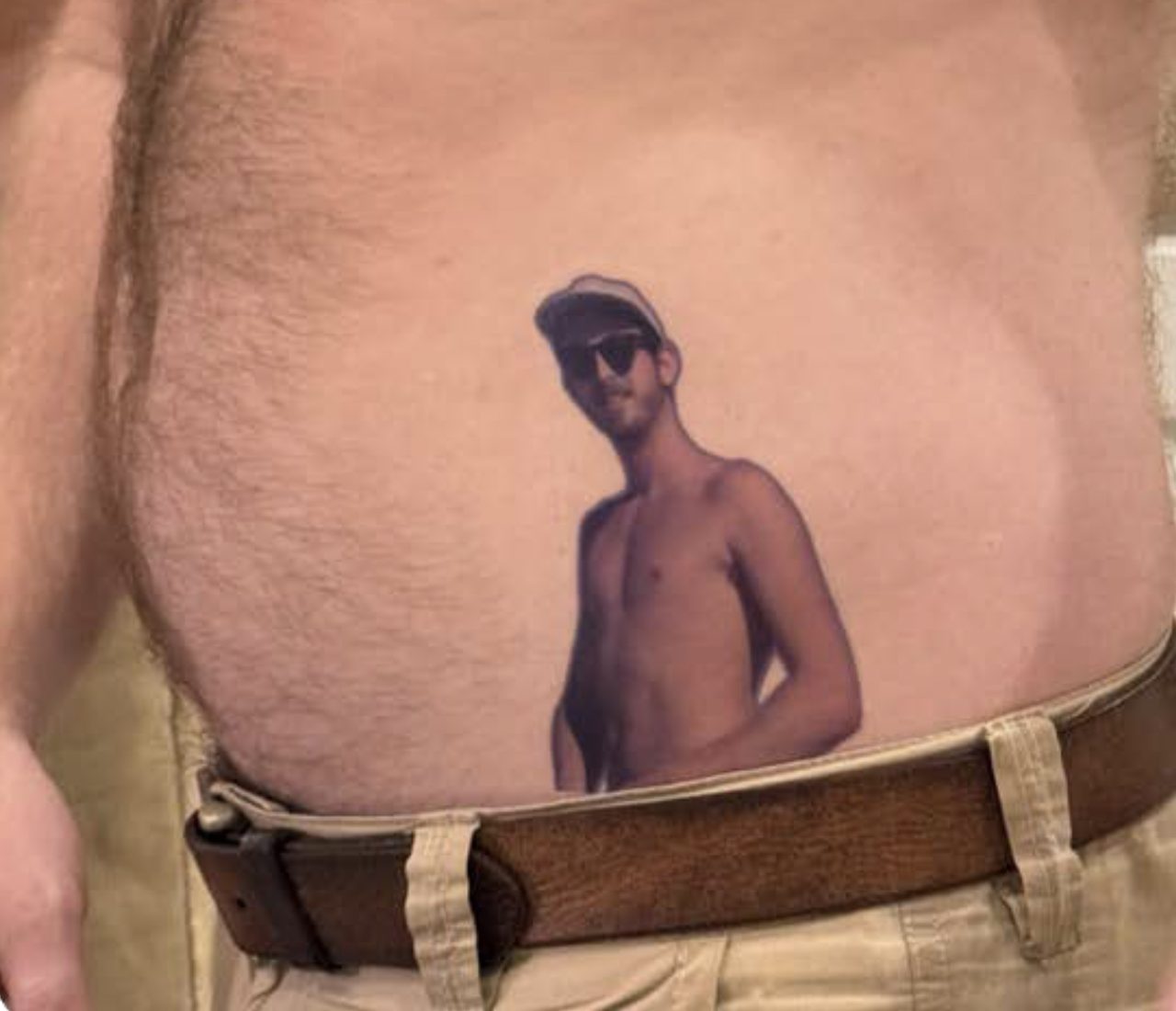 A large temporary tattoo of a man's portrait applied across someone's torso.