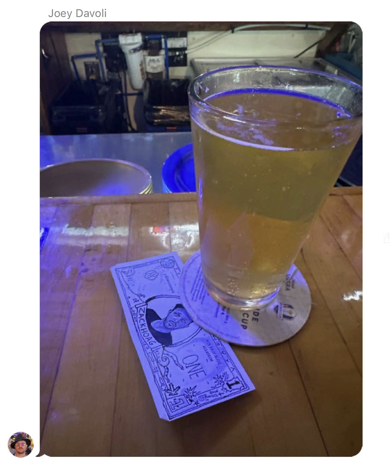 A single Zack Back note on a bar counter beside a glass of beer.